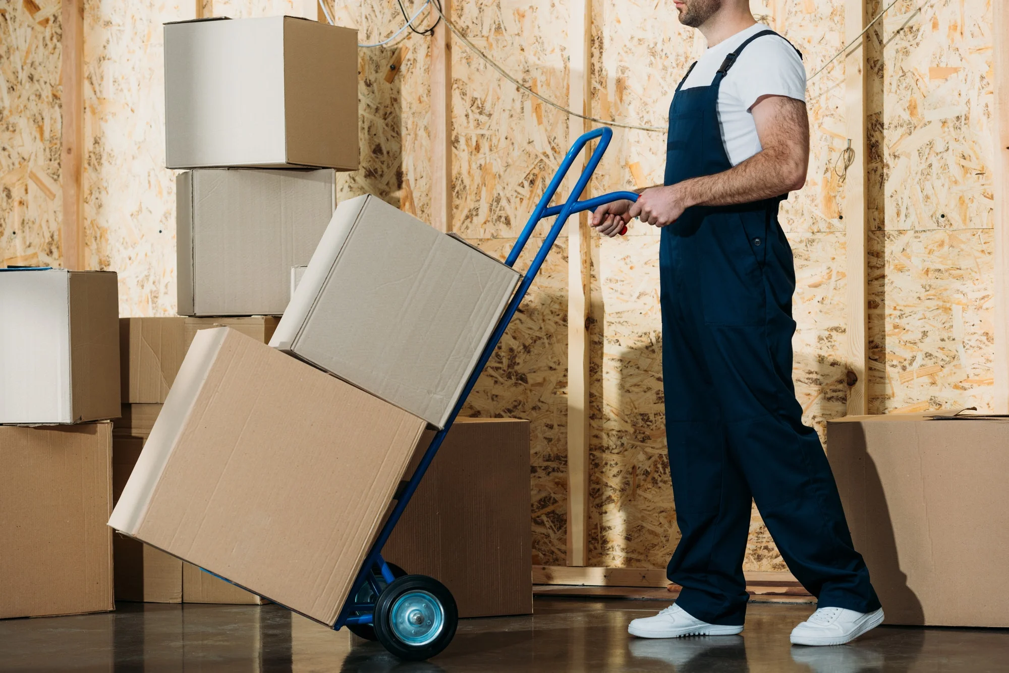 delivery-man-carrying-boxes-on-hand-truck